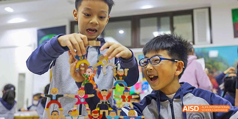 A male student showing a colorful, self-made sculpture at Beijing 21st Century School.