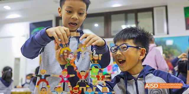 A male student showing a colorful, self-made sculpture at Beijing 21st Century School.