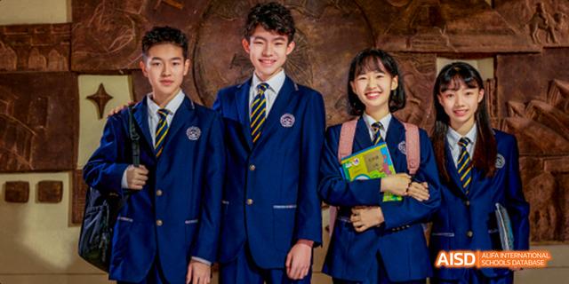 Three students in school uniforms smiling for a picture at Beijing 21st Century School.