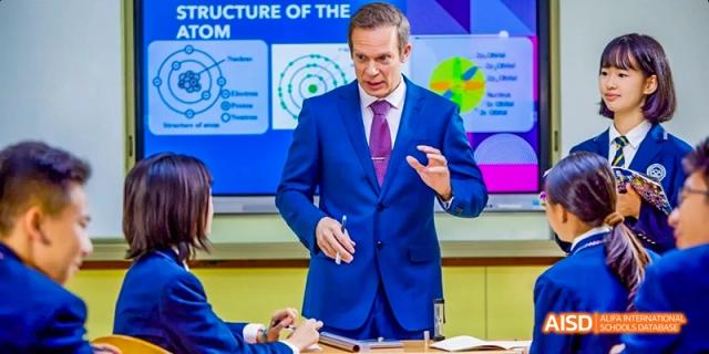A male teacher lecturing about the structure of the atom in a classroom at Beijing 21st Century School.