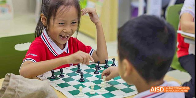 A young boy and a girl playing a game of chess at Beijing 21st Century School.