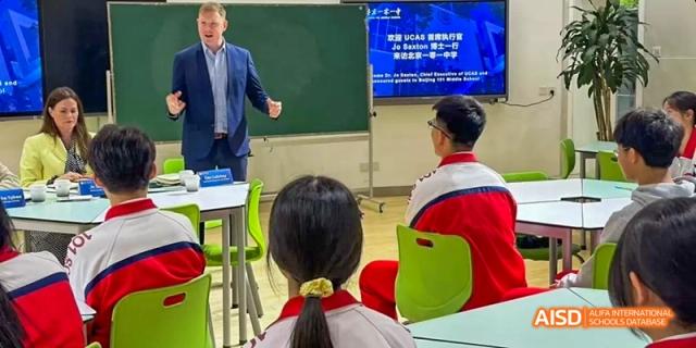 A student is seated at a table, looking at something on the table at Beijing 101 Middle School.