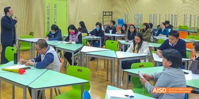 Students are seated around a table, engaged in a discussion with a teacher at Beijing 101 Middle School.