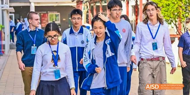 A group of students in lab coats are looking at a tablet at Beijing 101 Middle School.