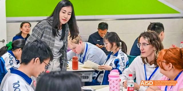 A teacher is instructing students who are seated at a table at Beijing 101 Middle School.