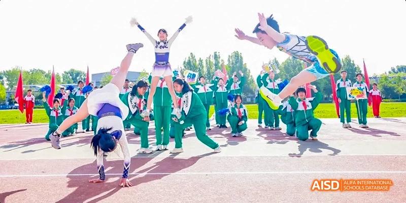A group of students in green uniforms are performing a synchronized dance or routine at an outdoor event at Beijing 101 Middle School.