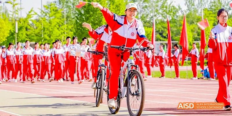 Students in red and white uniforms are riding bicycles in a synchronized formation at Beijing 101 Middle School.