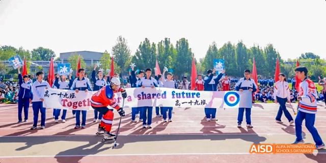 A group of students in red and white uniforms are holding a banner that says "Shared Future" in both Chinese and English at Beijing 101 Middle School.