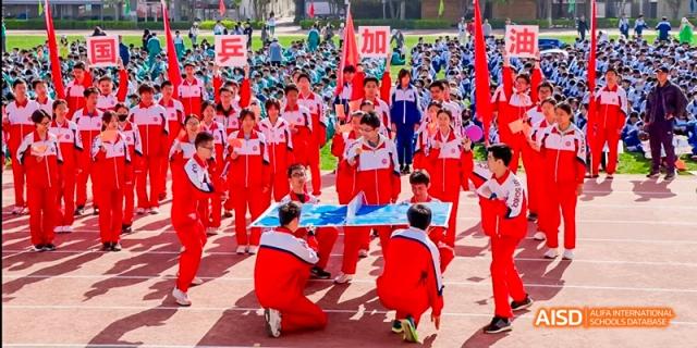 Students in red and white uniforms are performing a group dance or routine at an outdoor event at Beijing 101 Middle School.