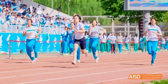 Two female students are running a race on a sports track at Beijing 101 Middle School.