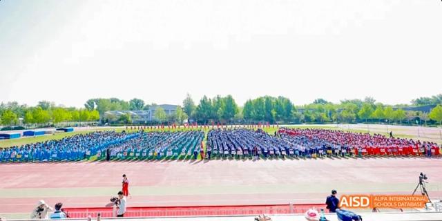 A large group of students are arranged in neat rows on a sports field, possibly for a formation or ceremony at Beijing 101 Middle School.