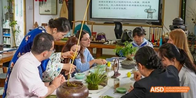 A group of students and a teacher are seated at a table, preparing a salad at Beijing 101 Middle School.