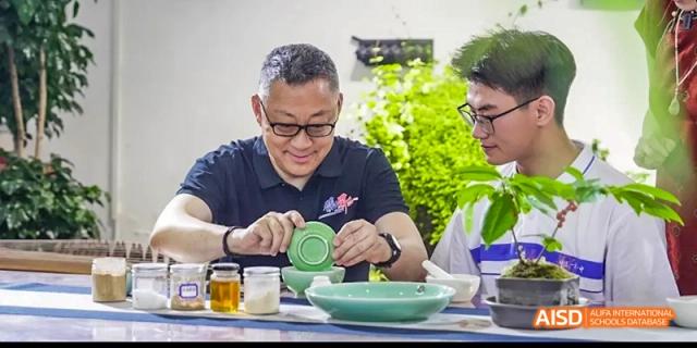 A male student is preparing a salad at a table with a potted plant at Beijing 101 Middle School.