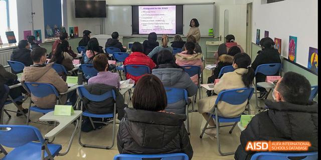 Beijing Bacui Bilingual School Adults attending a lecture or meeting in a classroom setting.