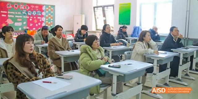 Beijing Bacui Bilingual School A group of adults sits at desks, attending a class or meeting in a classroom.