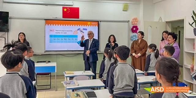 Beijing Bacui Bilingual School An adult guest speaker is in a classroom with students during a presentation.