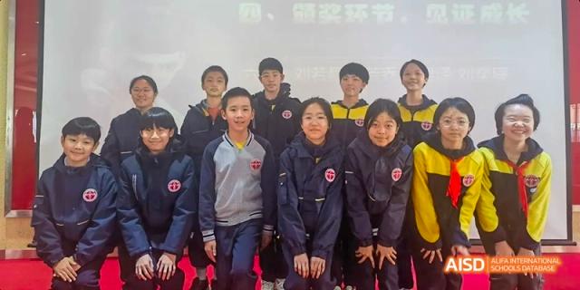 Beijing Bacui Bilingual School A group of male and female students poses together for a group photo.