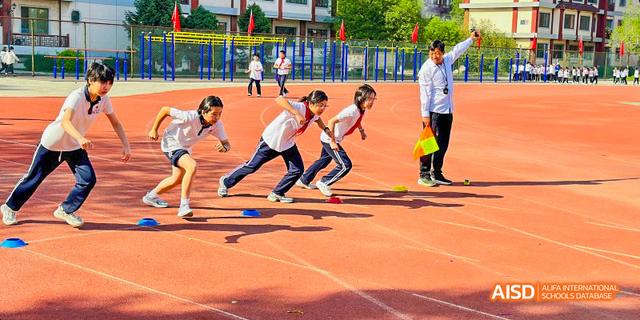 Beijing Bacui Bilingual School A group of students crouches at the starting line of a race on a running track.