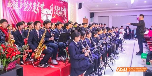 Beijing Bacui Bilingual School Students in blue uniforms playing instruments as part of a school orchestra.