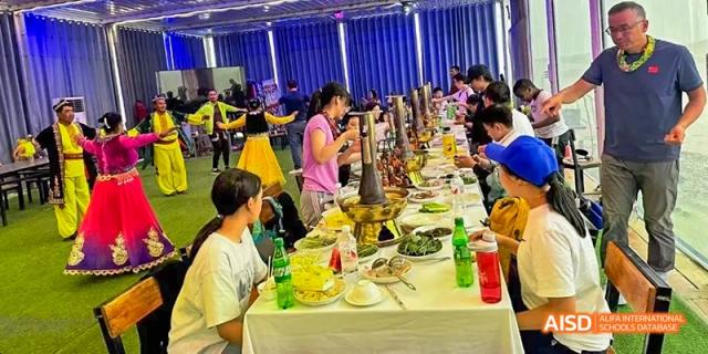A photo showing students and teachers standing together in a cafeteria, at Beijing Enlighten School.