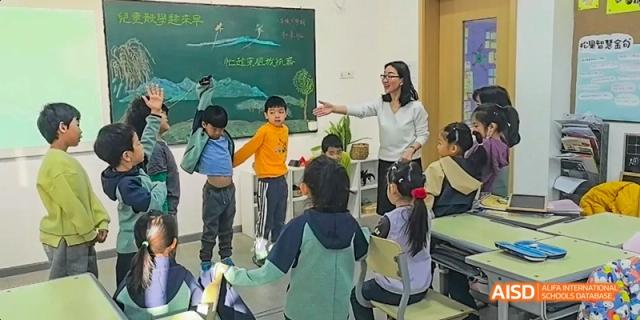 A photo showing a teacher teaching a group of students, at Beijing Enlighten School.