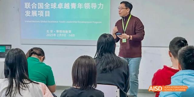 A photo showing a teacher explaining something to students, at Beijing Enlighten School.