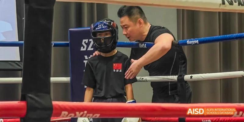 A photo showing a boxing teacher teaching a student how to box, at Beijing Enlighten School.