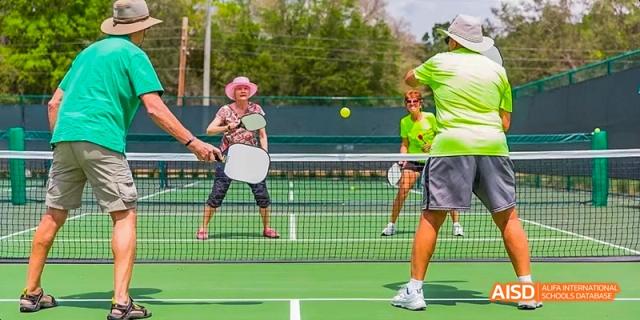 A photo showing two men playing tennis, at Beijing Enlighten School.