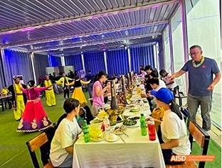 A photo showing students in a cafeteria with teachers, at Beijing Enlighten School.
