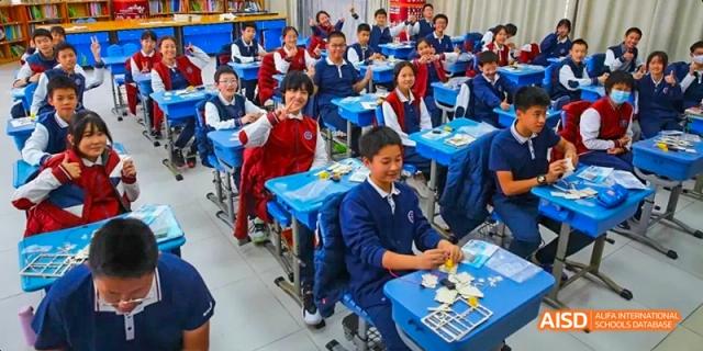 A busy classroom full of students from Beijing Haidian Foreign Language Academy working at their desks.