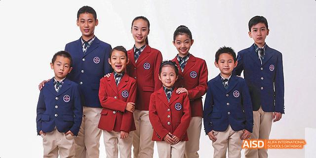 A group of students from Beijing Haidian Foreign Language Academy posing for a group portrait in their school uniforms.