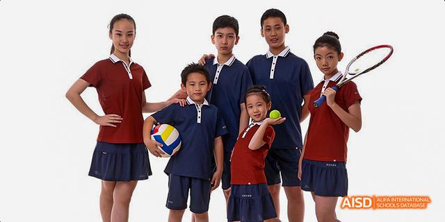 A group of students from Beijing Haidian Foreign Language Academy posing with sports equipment in their uniforms.