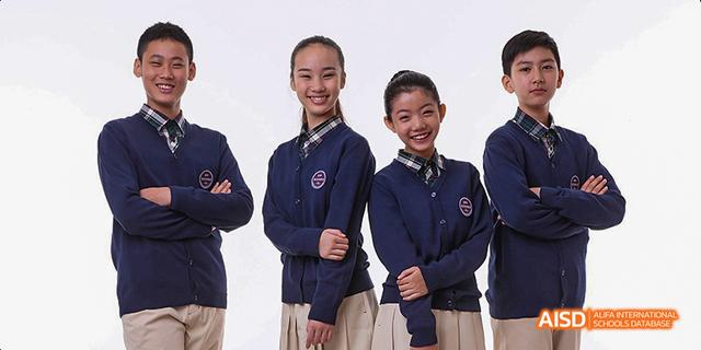 A group of students from Beijing Haidian Foreign Language Academy smiling in their school uniforms.