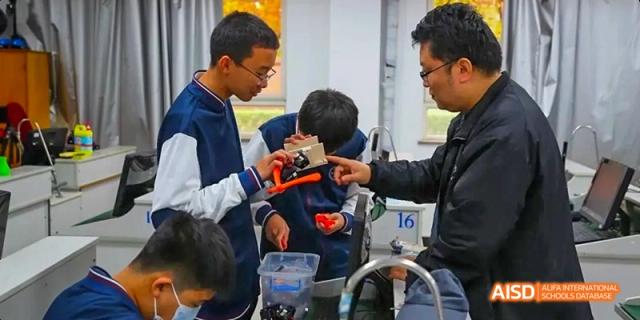 A teacher and student from Beijing Haidian Foreign Language Academy collaborating on a robotics project.