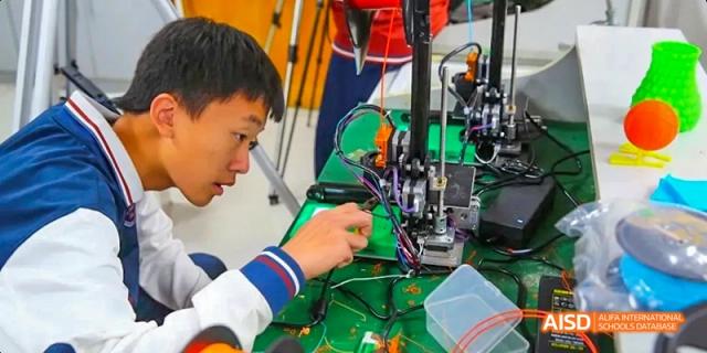 Students from Beijing Haidian Foreign Language Academy working with electronics in a robotics lab.