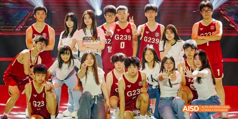 A group of male and female students from Beijing Haidian Foreign Language Academy wearing red basketball jerseys with "G239" on them, posing for a group photo.