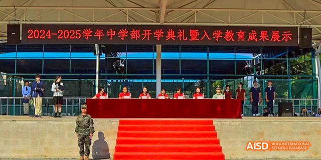 An opening ceremony for the middle school at Beijing Haidian Foreign Language Academy, with school officials seated on a stage.