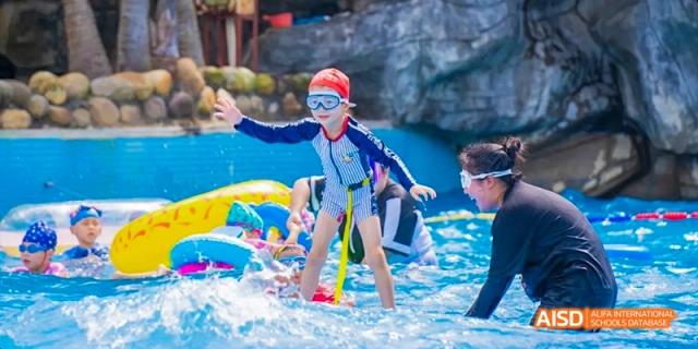 Young students from Beijing Haidian Foreign Language Academy playing in a school swimming pool.