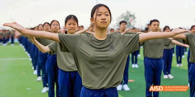 A female student from Beijing Haidian Foreign Language Academy with her arms extended, posing during a performance.