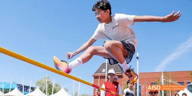 A male student from Beijing Haidian Foreign Language Academy high jumping during a track and field event.