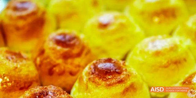 A close-up of a tray of yellow buns in the cafeteria of Beijing Haidian Foreign Language Academy.