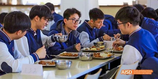 A group of students from Beijing Haidian Foreign Language Academy enjoying a meal together.