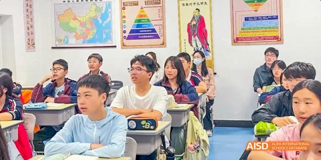 A classroom full of students, with one student raising their hand at Beijing Hui Xian School.
