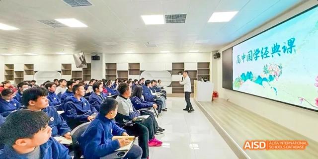 Students sitting in rows, looking at a screen in a computer lab at Beijing Hui Xian School.