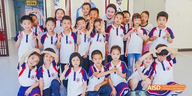 A group of students in red and white uniforms posing for a photo at Beijing Hui Xian School.