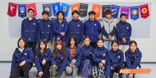 A group of students in blue jackets posing for a photo at Beijing Hui Xian School.