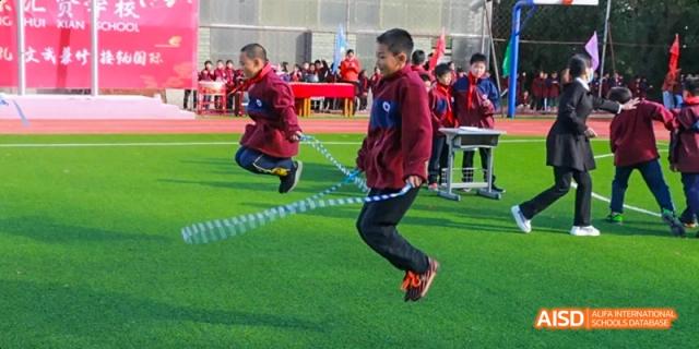 A student jumping high with a jump rope on a track at Beijing Hui Xian School.
