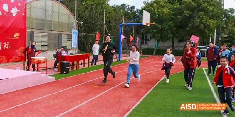 Students participating in a running race on a track at Beijing Hui Xian School.