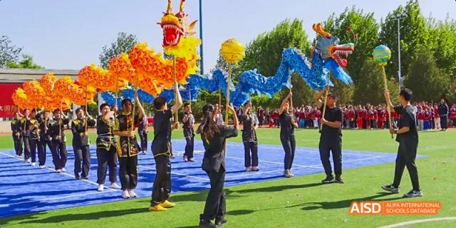 Students in a traditional dragon costume performing outdoors at Beijing Hui Xian School.