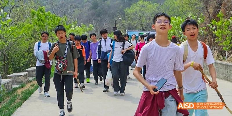 A group of students walking together outside on a sunny day at Beijing Hui Xian School.